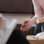 Close-up of woman's hands during counseling meeting with a profe